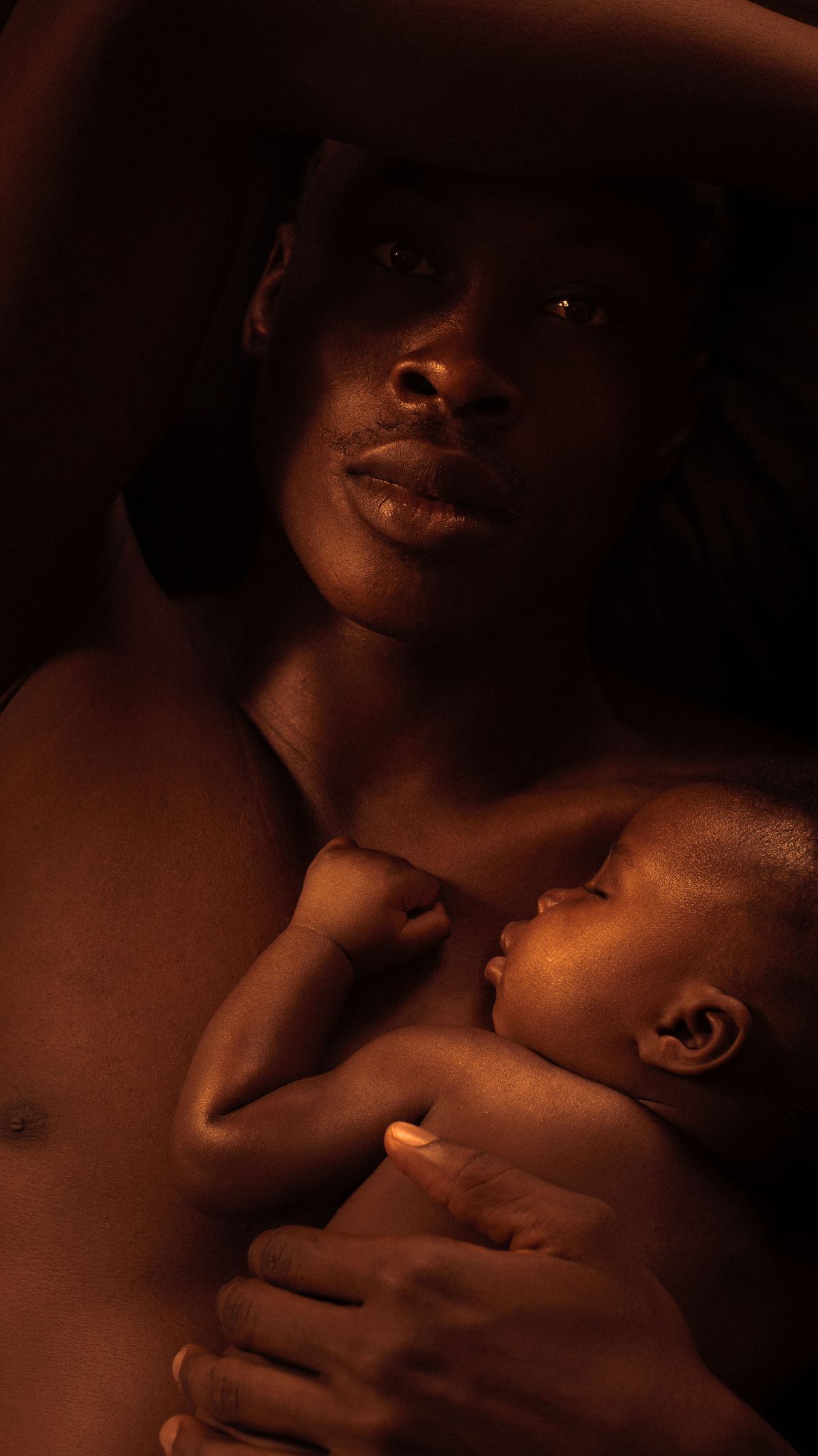 A parent cuddling their sleeping baby in soft daylight